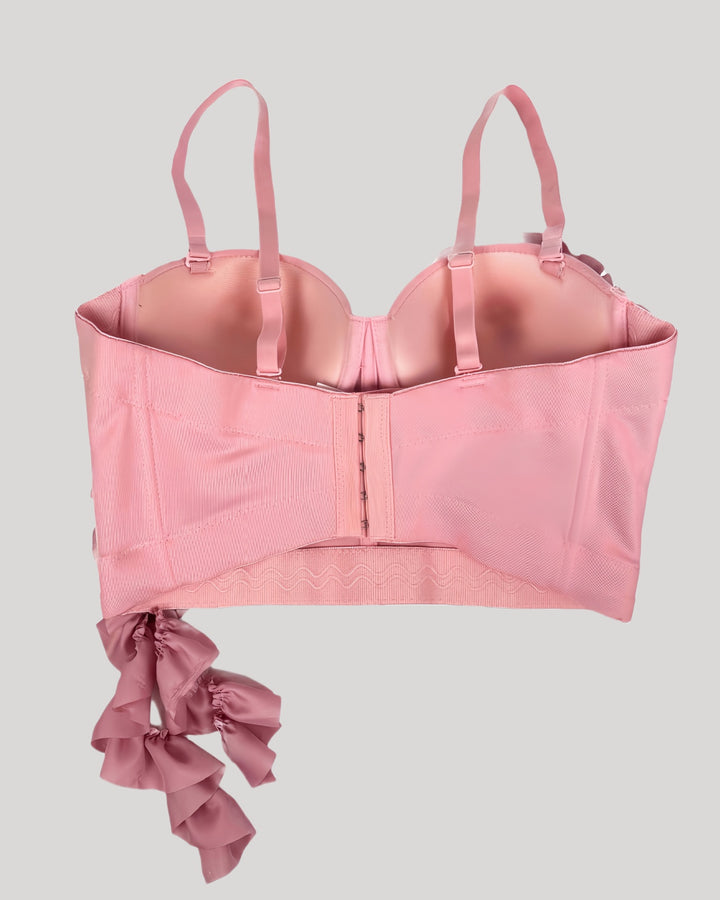 Back view of pink corset with adjustable straps and ruffle detail