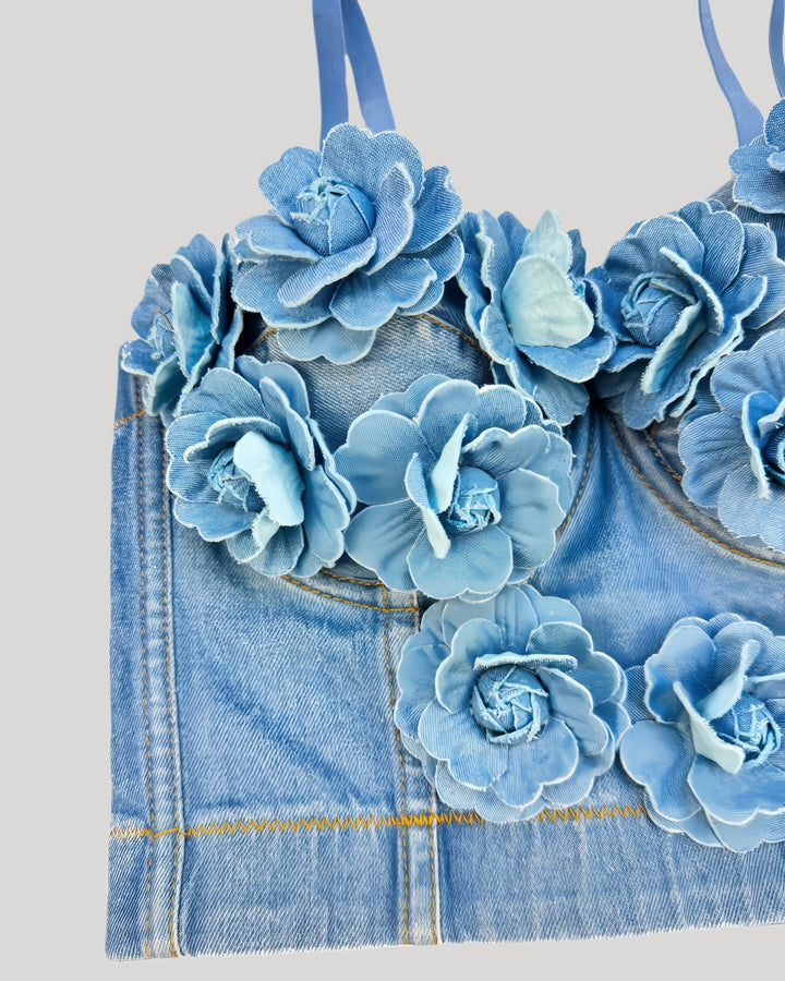 Detail view of blue denim corset with 3D handmade flowers