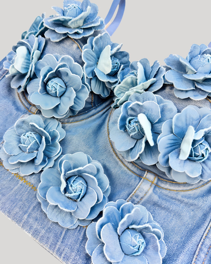 Detail view of blue denim corset with 3D handmade flowers