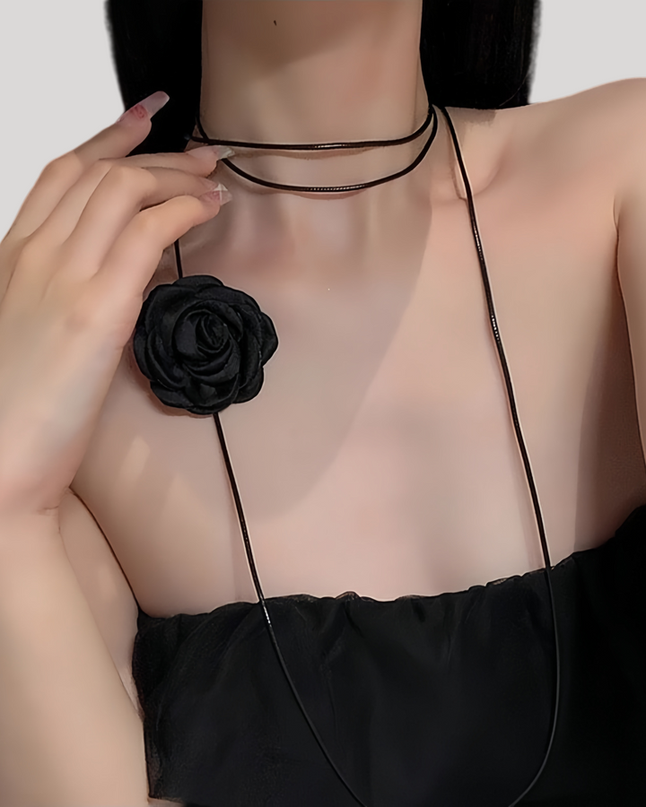 Model in black camellia ribbon choker with flower off-center