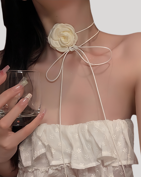 Model wearing white camellia choker with bow-tied satin ribbon