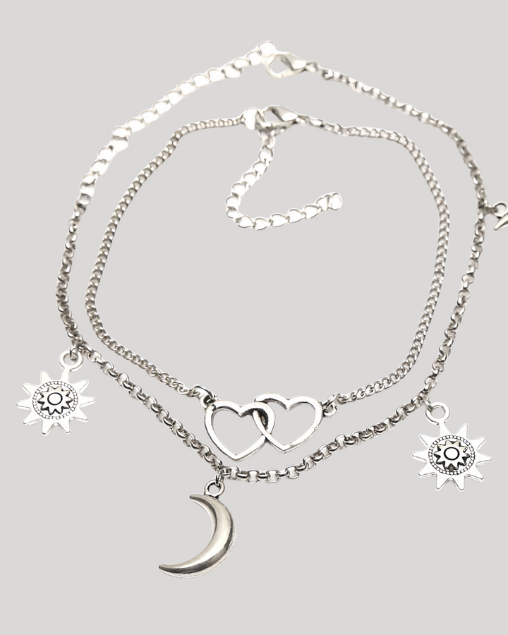 Product flat lay of silver celestial anklet with heart and moon charms