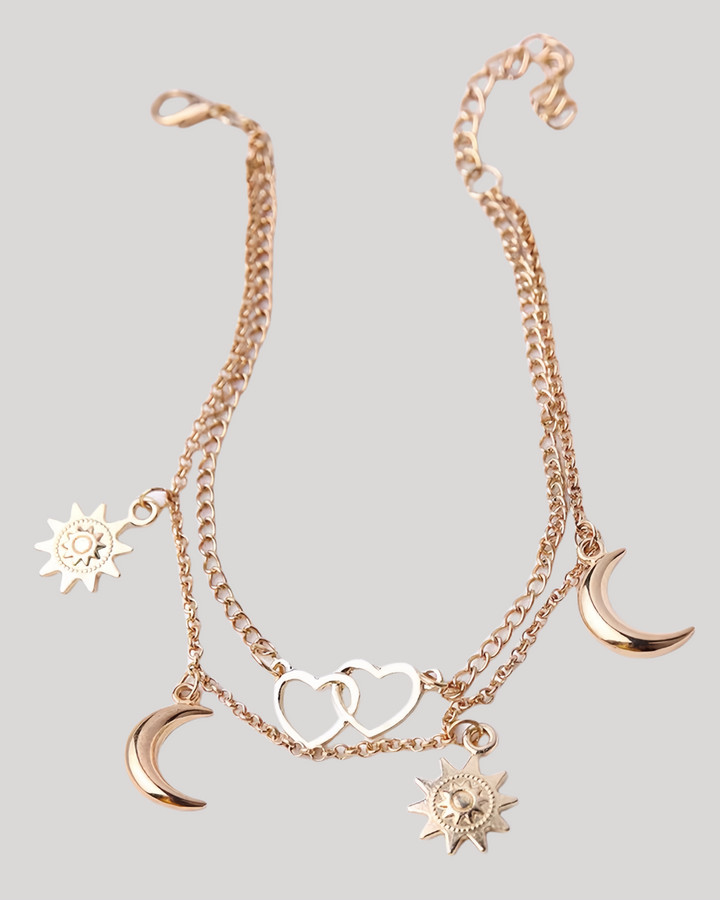 Product flat lay of gold celestial anklet with heart and moon charms