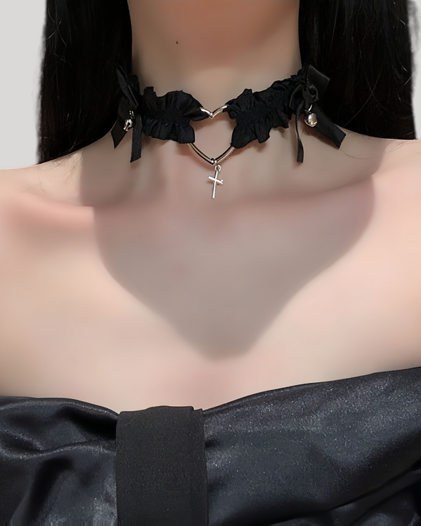 Model in black heart choker with dangling silver cross and ribbon bows