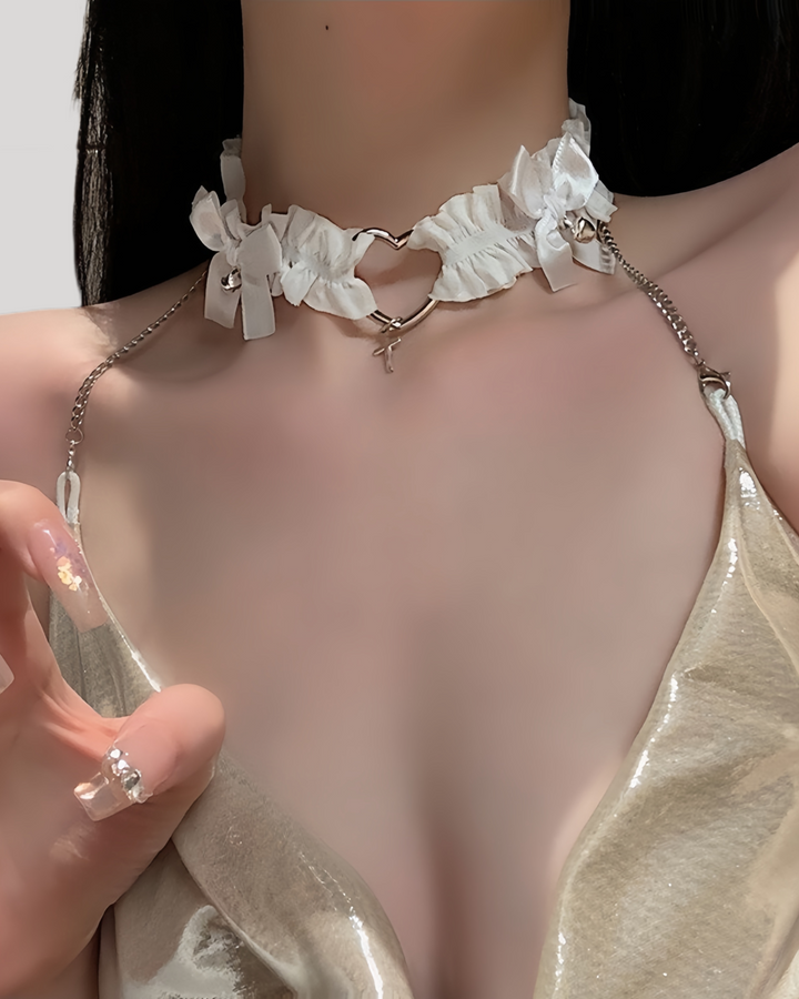 Model in white lace heart choker with metallic chain straps and cross charm