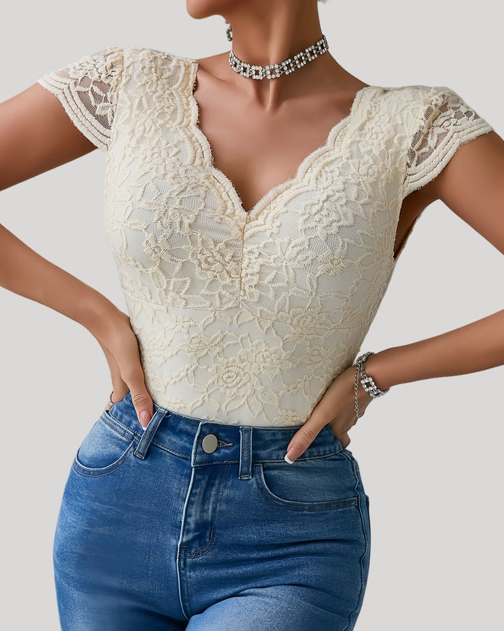 Close-up of beige lace bodysuit with scalloped neckline and cap sleeves