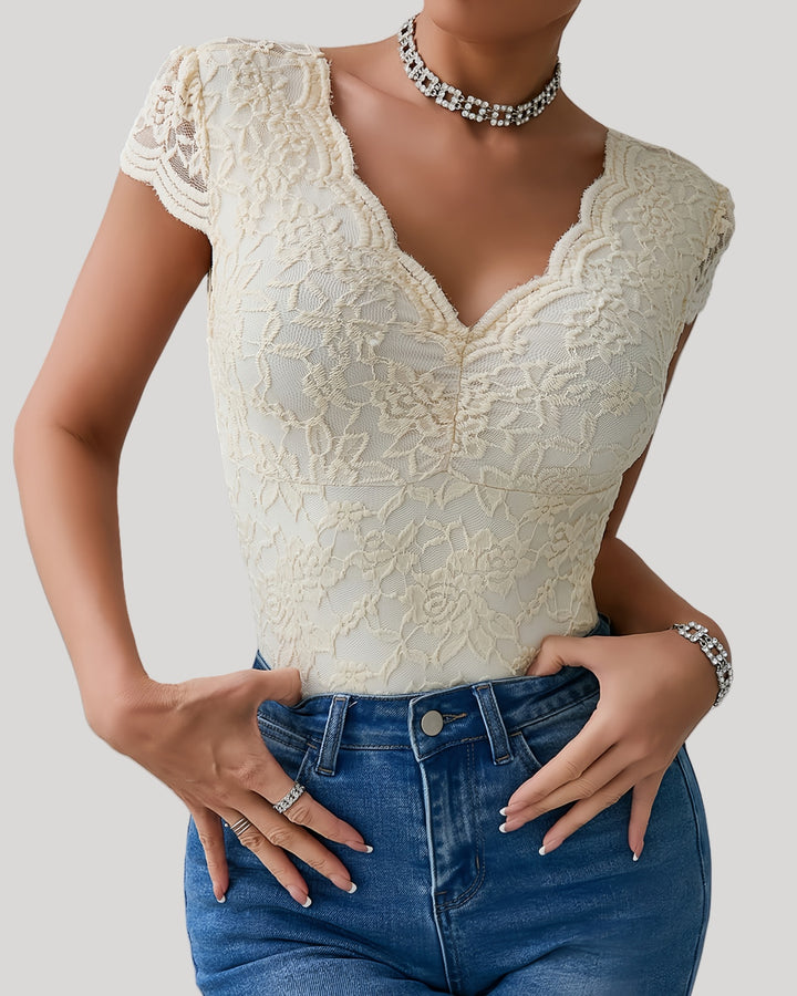 Close-up of beige lace bodysuit with scalloped neckline and cap sleeves