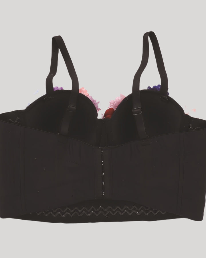 Back of black corset with adjustable straps and hook-and-eye closure