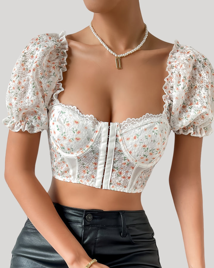 Woman in white floral bustier with puff sleeves and lace neckline