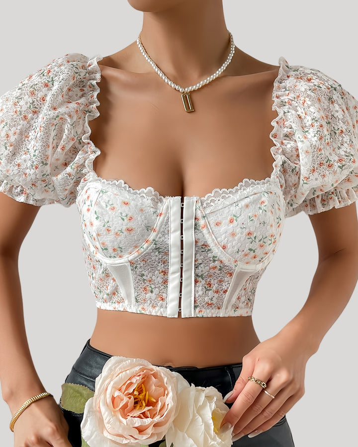 Woman in white floral bustier with puff sleeves and lace neckline