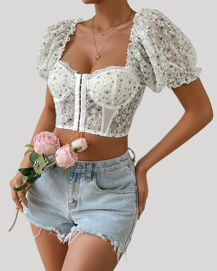 Woman in white floral bustier with puff sleeves and lace neckline