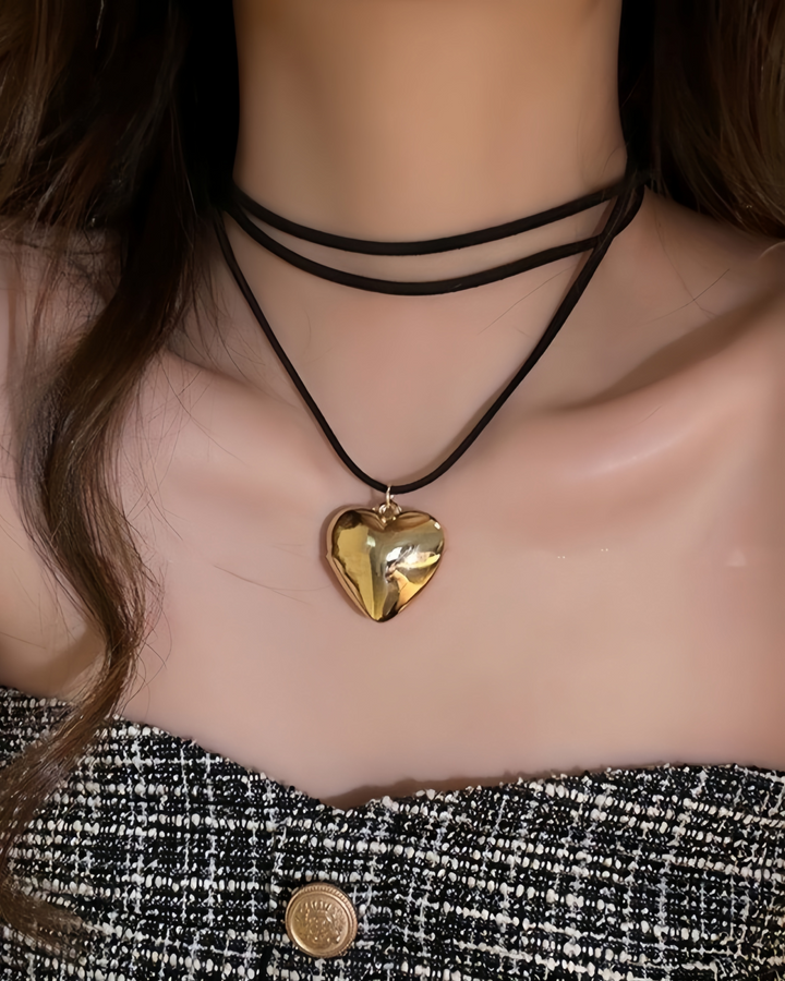 Gold heart pendant wrap choker on model with tweed strapless top