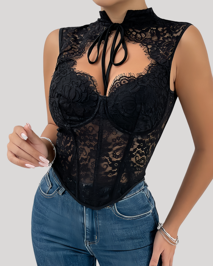 Black lace top worn by a person on a plain background