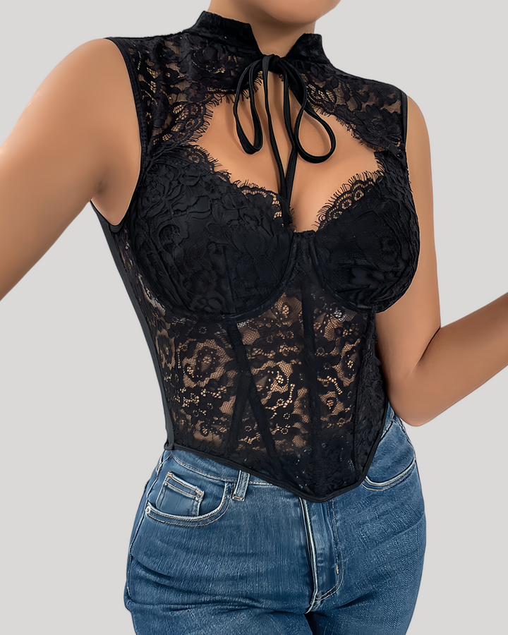 Black lace top worn over blue jeans on a neutral background