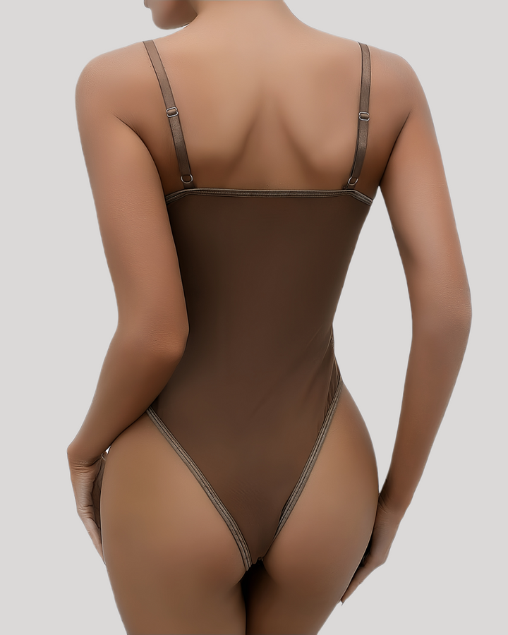 Brown lace bodysuit on model lying down, showcasing back mesh panel and thong cut