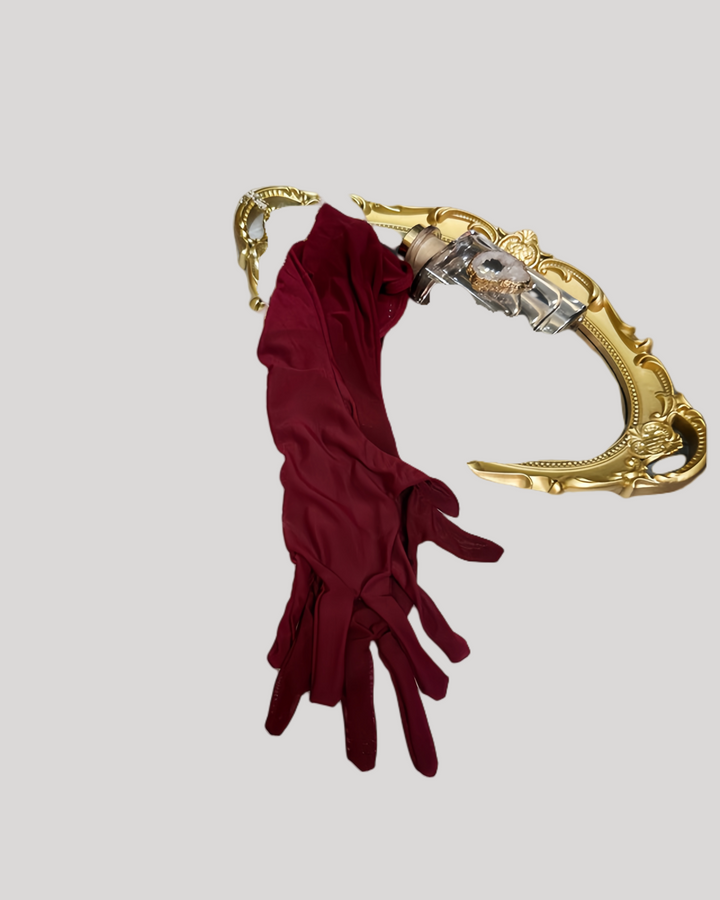 Maroon gloves draped over a gold ornate armrest on a light gray background