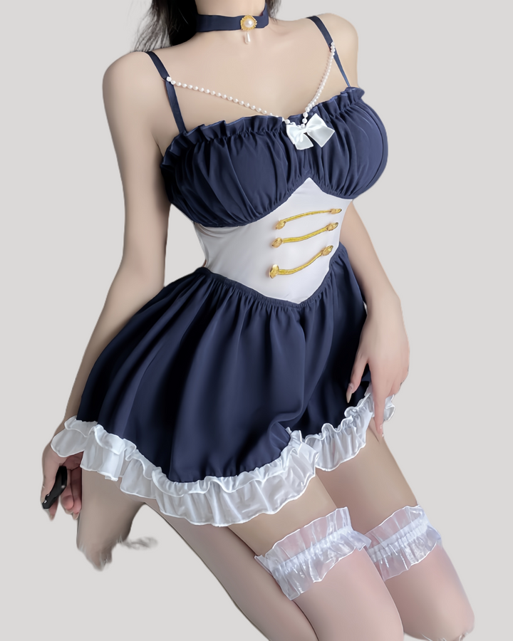 Model wearing a navy blue babydoll with pearl straps and gold button waist detailing