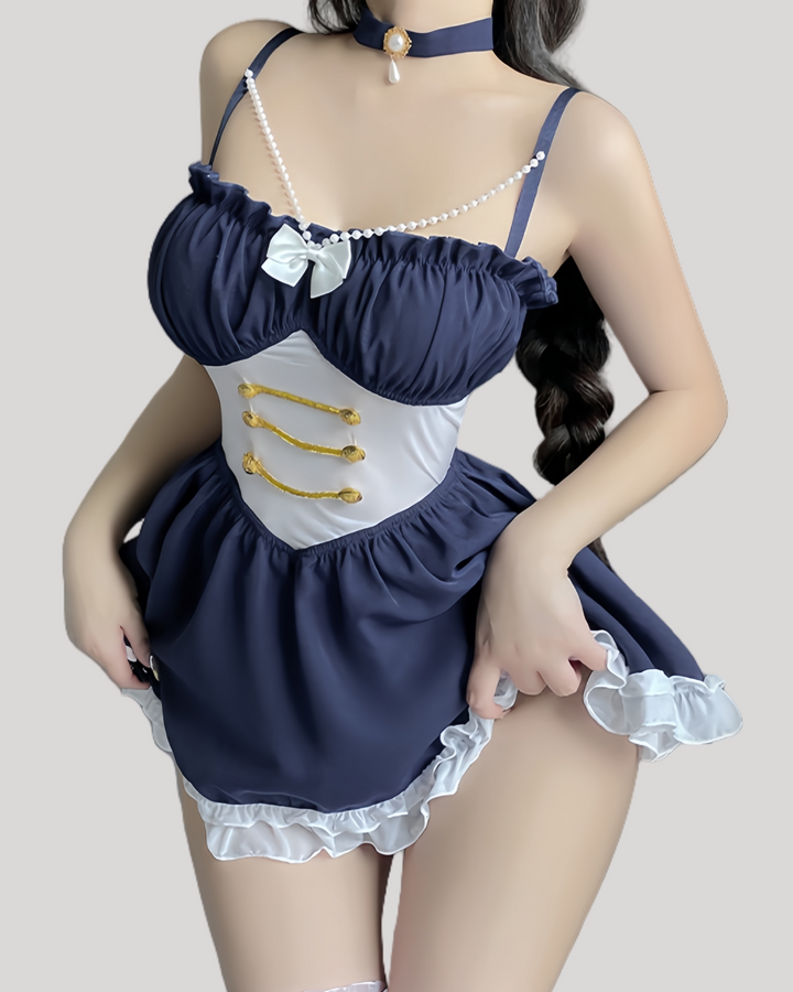 Model wearing a navy blue babydoll with pearl straps and gold button waist detailing