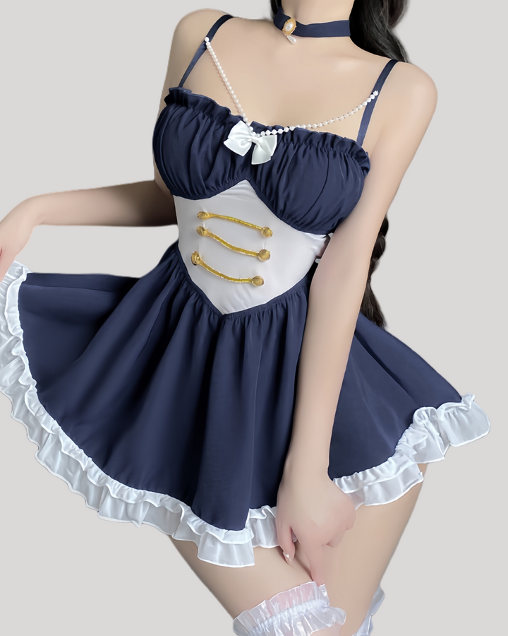Model wearing a navy blue babydoll with pearl straps and gold button waist detailing