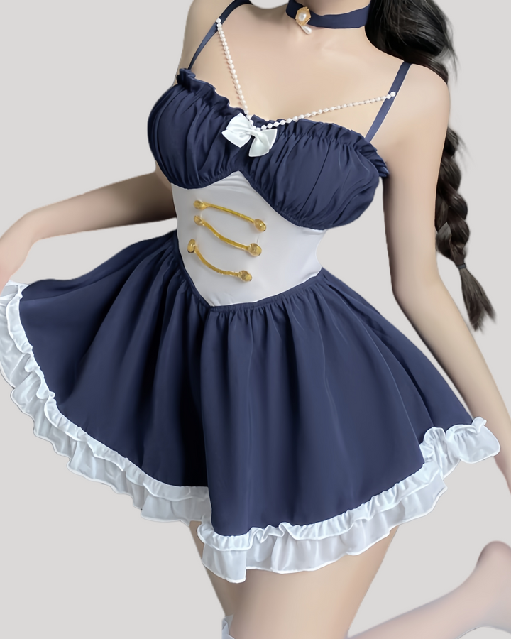 Model wearing a navy blue babydoll with pearl straps and gold button waist detailing