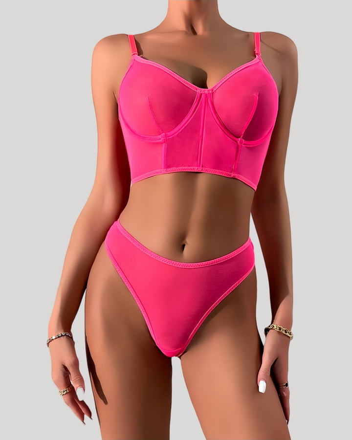 Front view of neon pink sheer mesh lingerie set on model