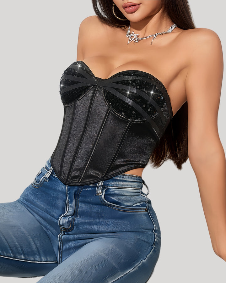Model in black strapless sequin corset top with jeans