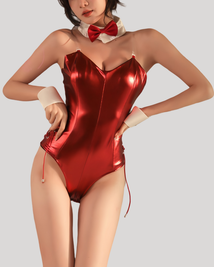 Model wearing a red patent leather bunny bodysuit with attached tail, clear shoulder straps, matching black bunny ears headband, white collar with black bow tie, and cuff wristbands.
