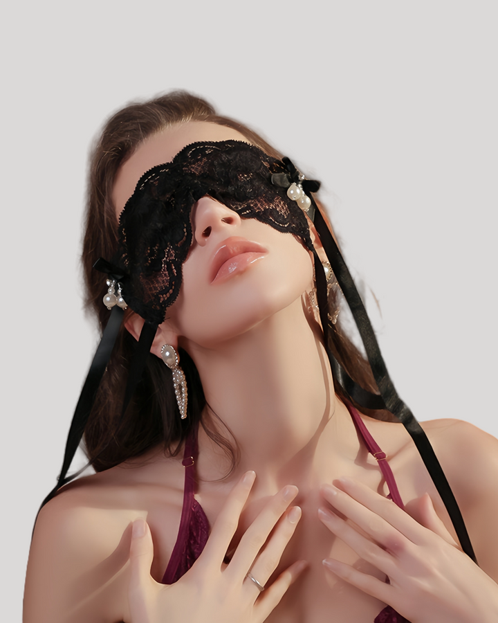 Model wearing black lace blindfold with satin ties