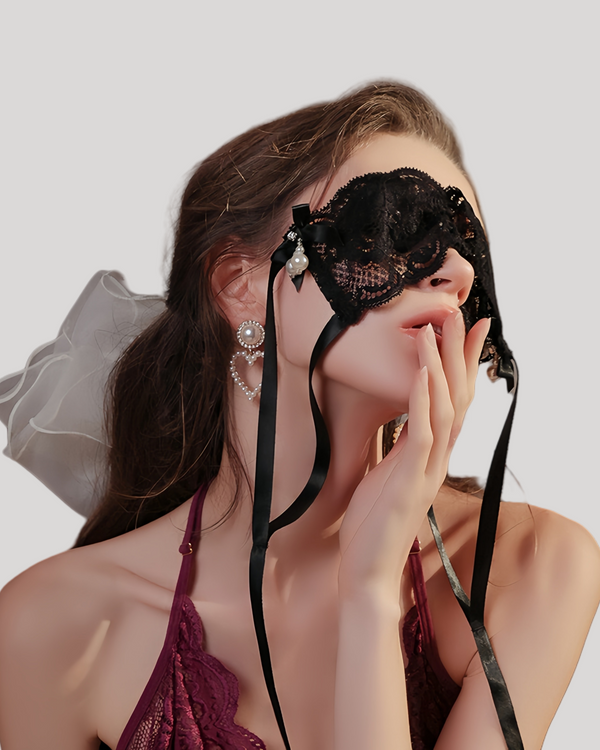Side profile of model in lace blindfold with pearl accents