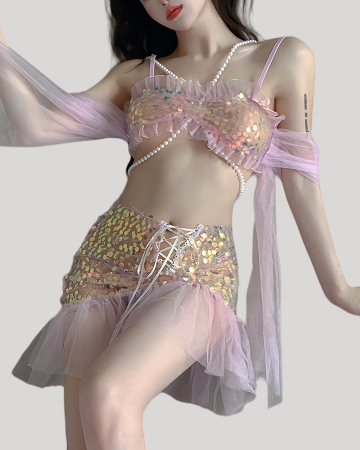 Model wearing glittering mermaid fantasy dress with pearl chain and tulle sleeves