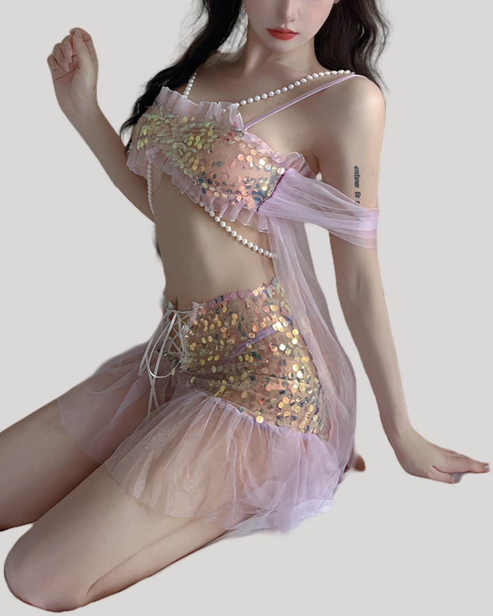 Model wearing glittering mermaid fantasy dress with pearl chain and tulle sleeves