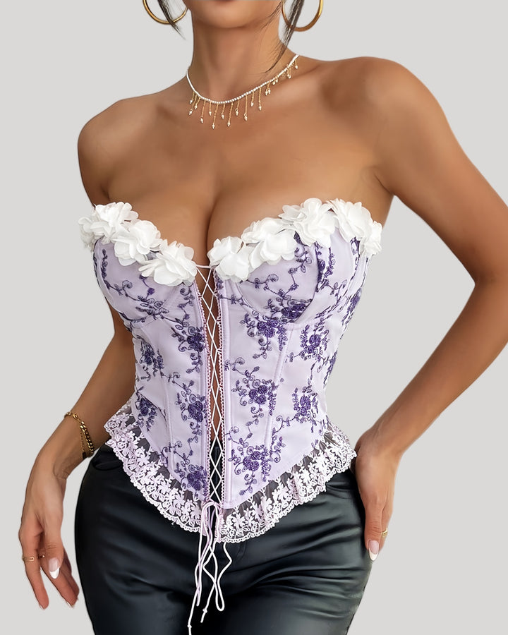 Woman wearing purple floral embroidered corset with lace-up front and 3D flower bustline