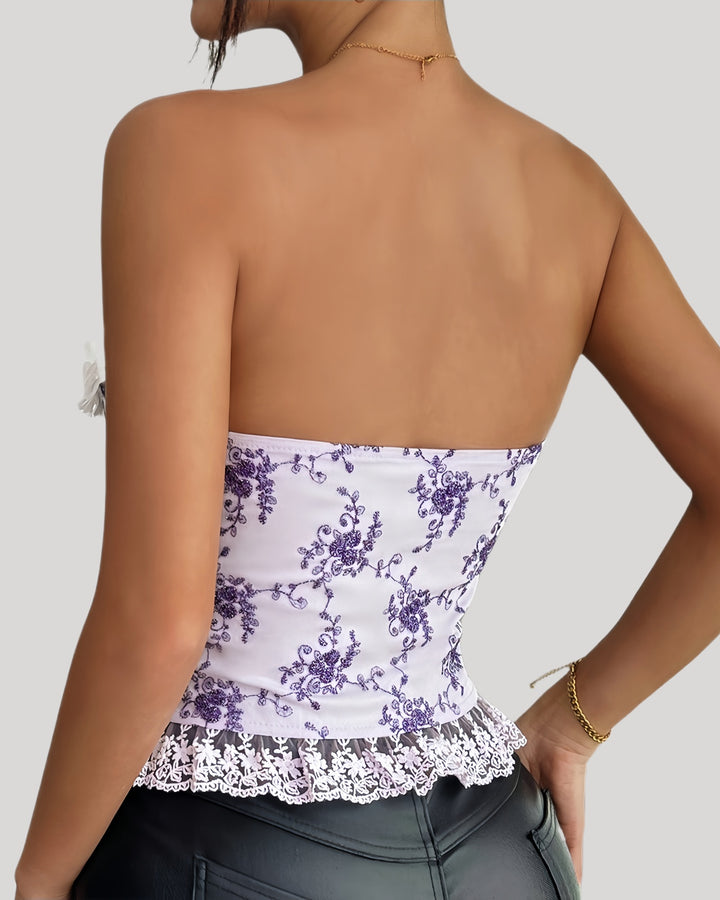 Woman wearing purple floral embroidered corset with lace-up front and 3D flower bustline
