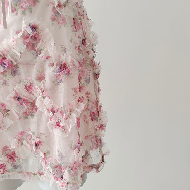 Detail shot of cascading ruffle layers and floral print on sheer mesh.