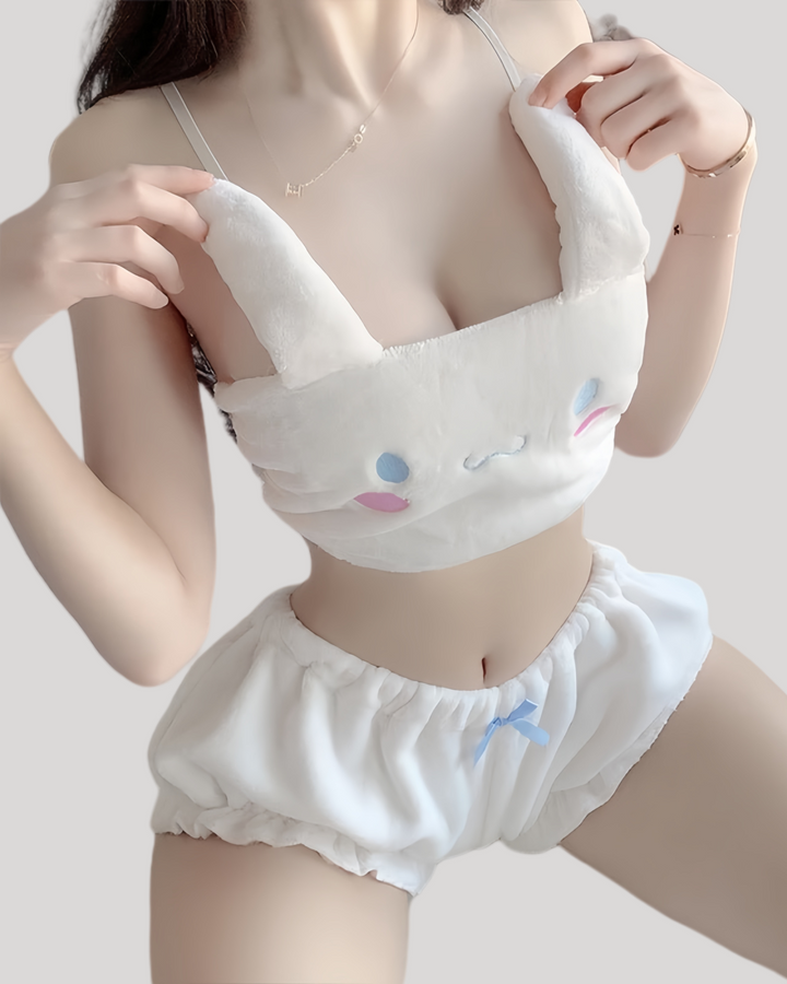 Woman wearing white plush bandeau cami with floppy Cinnamoroll ears and embroidered face, paired with ruffled elastic-waist shorts featuring a small blue bow