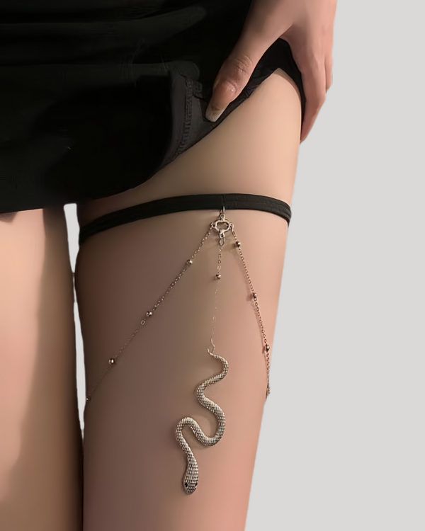 Silver snake leg chain harness styled under a black mini dress