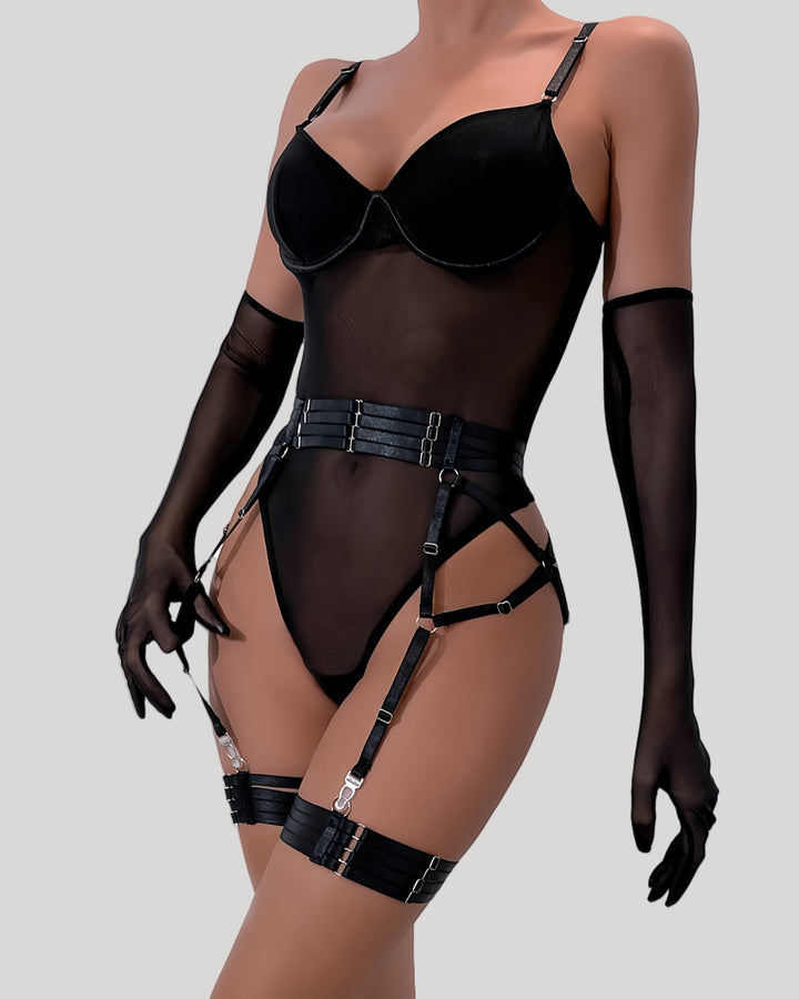 Front view of model wearing black mesh and velvet strap bodysuit with matching gloves