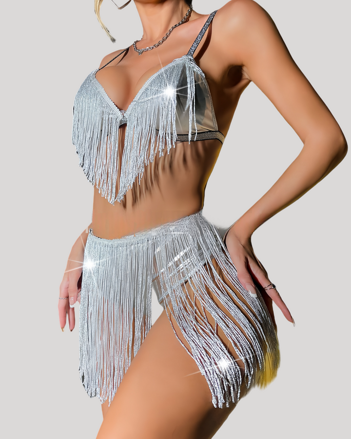 Side-angle shot showing silver-fringe bikini set with mesh inset and metallic straps on a seated model.