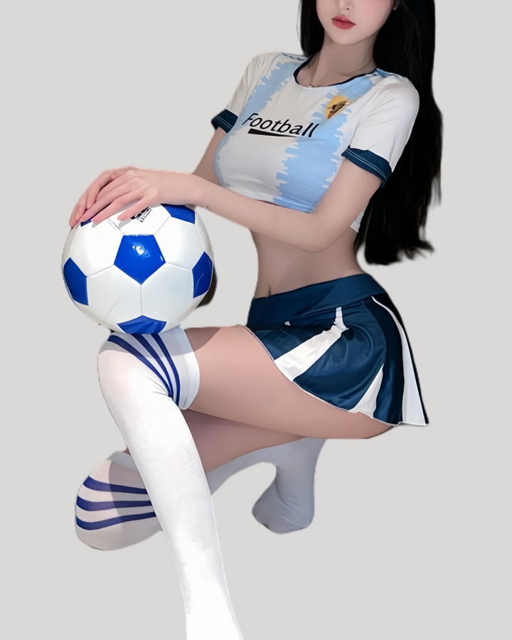Model in sky-blue cropped football top and pleated mini skirt holding a soccer ball.