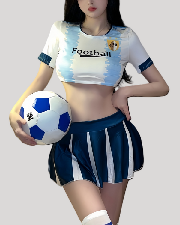 Model in sky-blue cropped football top and pleated mini skirt holding a soccer ball.