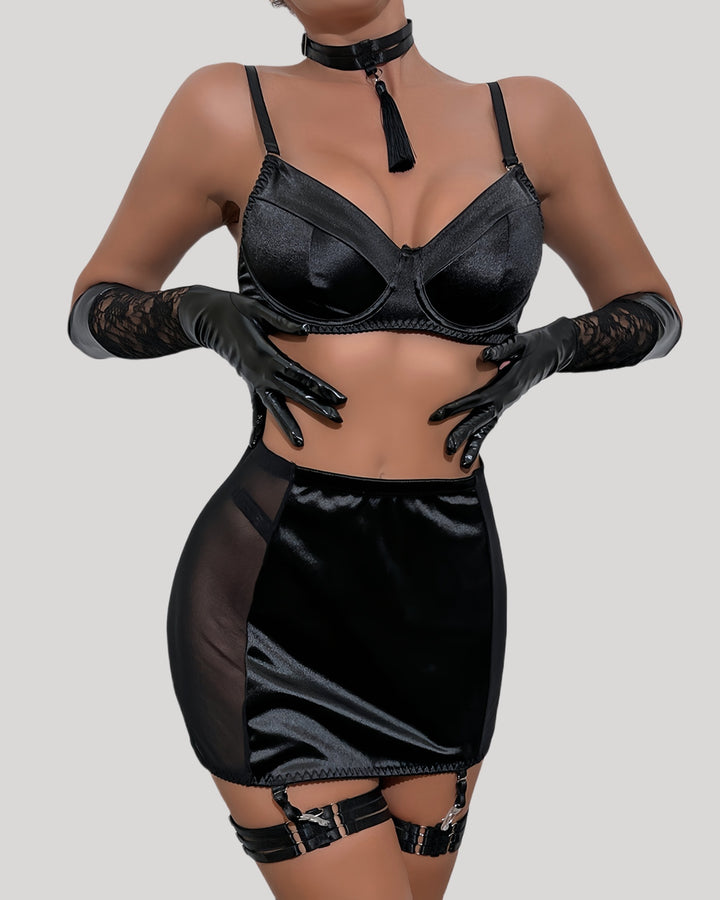 Model wearing black satin bra and mini skirt set with tassel choker