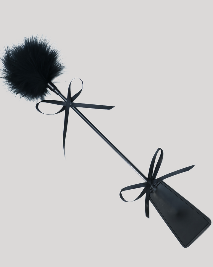 Black feather and leather paddle with satin ribbon accents